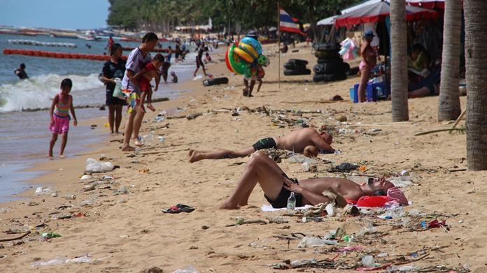 Tourists share a spot in the sun with washed-up garbage on Jomtien Beach in Pattaya, Monday, October 16.