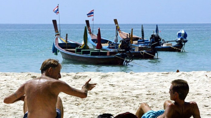 Western tourists soak up the sun on Kata Beach, Phuket. (AP Photo)