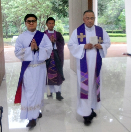 Devine Healer Fr. Corsie Legaspi (far right) enters the Assumption church.