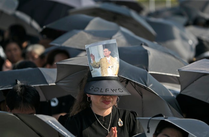 A mourner prays in a sea of black umbrellas at the funeral procession and royal cremation ceremony in Bangkok. (AP Photo/Wason Wanichakorn)
