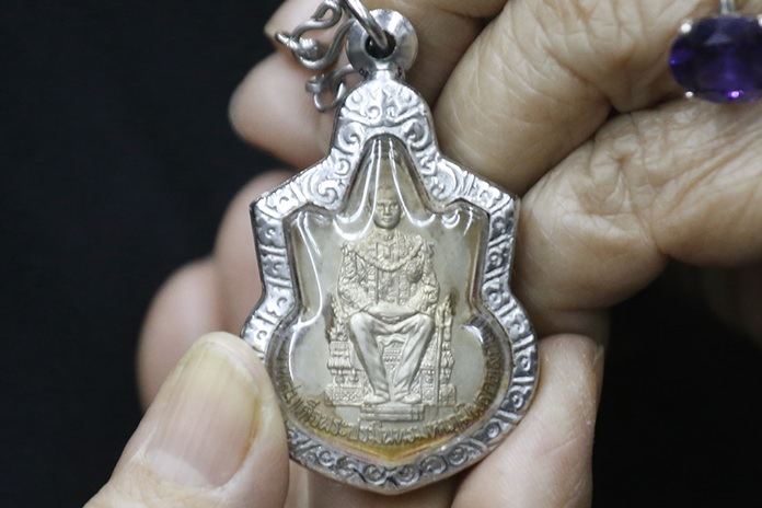 An amulet bearing the image of late Thai King Bhumibol Adulyadej is displayed by shopkeeper Ladda Klaisansom, 73. (AP Photo/Sakchai Lalit)