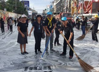 Some of the nearly 1,000 people who swept through Pattaya to clean up the city and shoreline in advance of the royal cremation ceremony, shown here cleaning South Pattaya Road in front of Wat Chaimongkol Royal Temple.