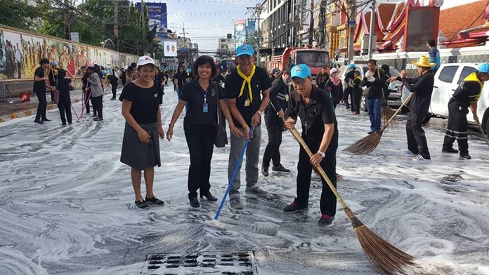 Some of the nearly 1,000 people who swept through Pattaya to clean up the city and shoreline in advance of the royal cremation ceremony, shown here cleaning South Pattaya Road in front of Wat Chaimongkol Royal Temple.