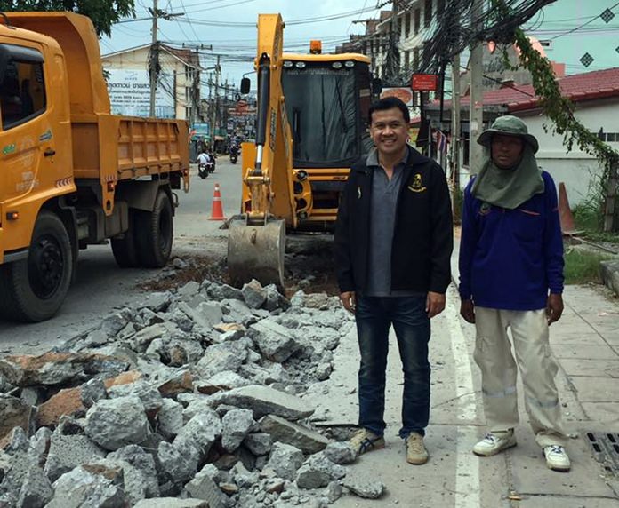 Sub-district Councilman Metasit Somla visits with Nongprue workers repairing Boonsamphan Soi 7 after it was damaged by flooding.