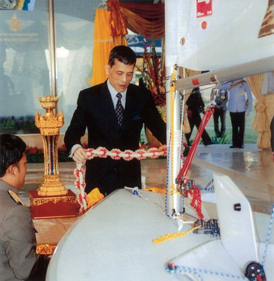 His Majesty King Maha Vajiralongkorn, then the Crown Prince, places a garland on a Laser sailing boat presented to him during the grand opening of the new Royal Varuna clubhouse in 2004.