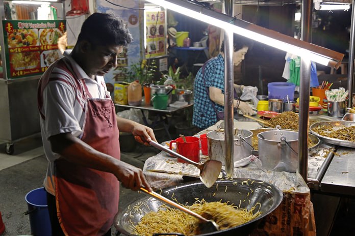 A cook stir-fries noodles at a street food stall in George Town on the island of Penang, Malaysia. (AP Photo/Adam Schreck)