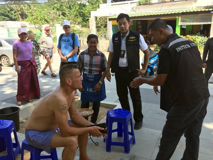 The regional director of the Marine and Coastal Resources Department, Thanet Mannoi, meets with foreign tourists in Pattaya to explain why Thailand has banned smoking on its beaches.