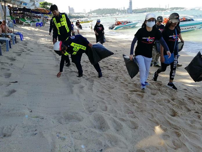 Special Task Force Law Enforcement officers and volunteers collect garbage and clean Pattaya Beach in Central Pattaya.