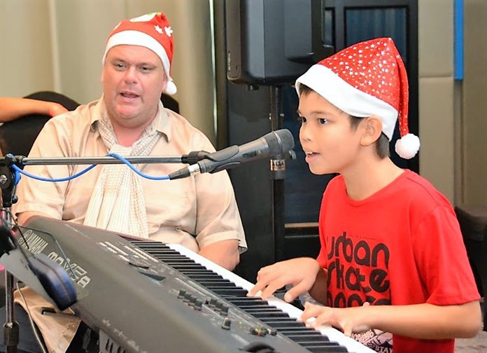 Marcus Tristan and Ben Rudolph provided the musical accompaniment for the PCEC’s Christmas Caroling. Here Ben does a solo song for everyone as Marcus looks on.