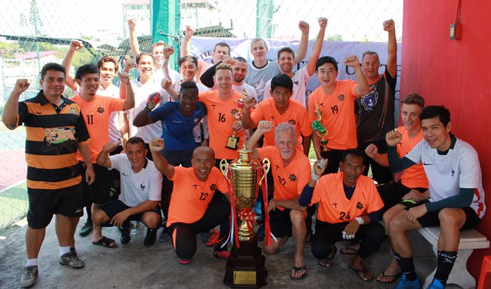 Champions and runner-up pose with the trophy at the conclusion of the charity football tournament at Palladium FC football fields in Pattaya, December 16.