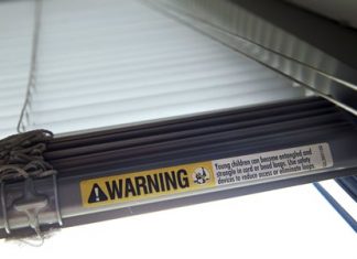 This file photo shows a warning label of strangulation risks from mini blind cords in Washington. According to a study released this month, children’s injuries and deaths from window blinds have not stalled despite decades of safety concerns. (AP Photo/Jacquelyn Martin)