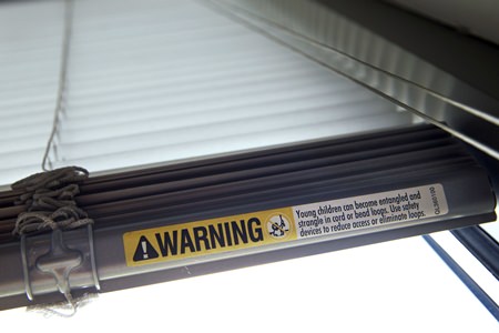 This file photo shows a warning label of strangulation risks from mini blind cords in Washington. According to a study released this month, children’s injuries and deaths from window blinds have not stalled despite decades of safety concerns. (AP Photo/Jacquelyn Martin)