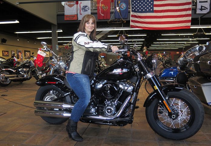 In this Dec. 12, 2017, photo, Terri Meehan poses on a 2018 Harley Softail Slim in Milwaukee’s House of Harley. Meehan took a riding course at the dealership as part of Harley-Davidson’s “Riding Academy,” an initiative the company hopes will help bring new customers. (AP Photo/Ivan Moreno)