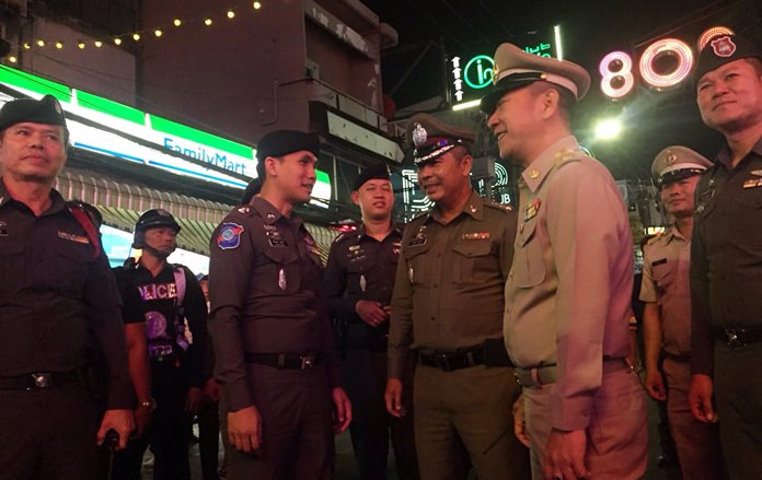 District Chief Naris Niramaiwong and Police Chief Pol. Col. Apichai Kroppech walk the nightlife strip with administrators and officers on Christmas night.