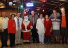 Rotarians and guests pose with Santa Claus at Prem’s Christmas party.