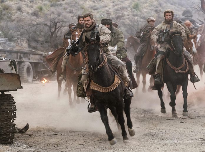 This image shows Chris Hemsworth (center) in a scene from “12 Strong.” (David James/Warner Bros. Entertainment via AP)