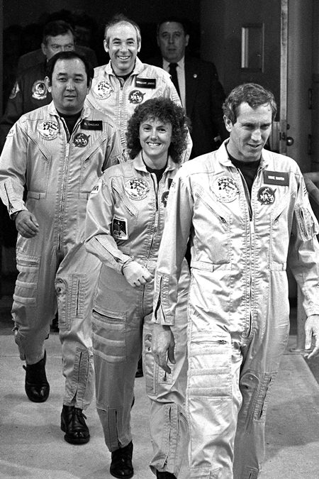 In this Jan. 28, 1986 file photo, four crew members of the space shuttle Challenger walk from their quarters at Kennedy Space Center in Floirda, en route to the launch pad. From foreground are pilot Mike Smith, school teacher Christa McAuliffe, mission specialist Ellison Onizuka and payload specialist Gregory Jarvis. (AP Photo/Steve Helber)