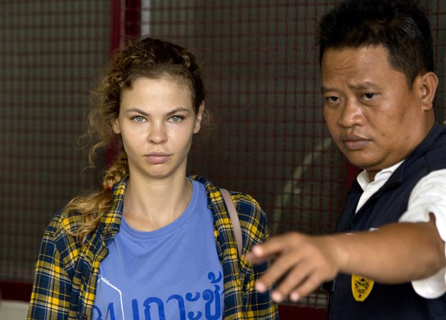 A police officer escorts Anastasia Vashukevich from a detention center in Pattaya, Wednesday, Feb. 28. (AP Photo/Gemunu Amarasinghe)