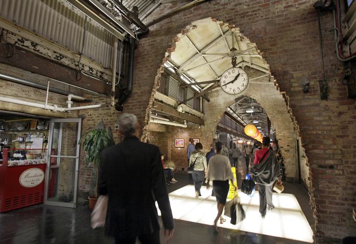Visitors walk through archways carved out of the brick walls at New York’s landmark Chelsea Market building in the Meatpacking District. Google, which has an office building across the street on Ninth Avenue, is reportedly close to reaching a $2.4 billion deal to add the Chelsea Market building. (AP Photo/Richard Drew, File)