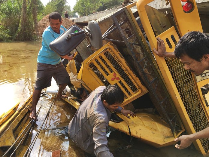Police and paramedics were called to a bridge construction site on Khao Maikaew-Huay Kai Nao Road to find the crane in a canal with the critically injured operator stuck inside.