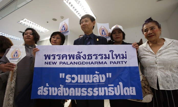Representatives of the New Palangdharma Party hold a poster before their registration to set up a political party at the Election Commission in Bangkok, Friday, March 2. (AP Photo/Sakchai Lalit)