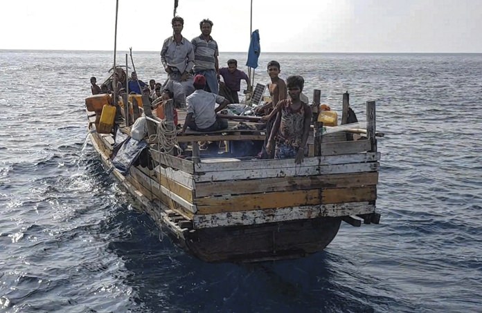In this March 31, 2018, photo, people are shown on a boat a day prior to it being found underneath a bridge near to a Thai island, damaged in a storm. (AP Photo/Assadawuth Suden)