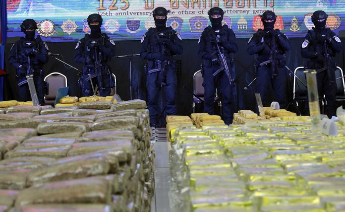 Policemen stand guard in front of seized drugs in Bangkok, Tuesday, April 3. (AP Photo/Sakchai Lalit)