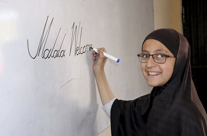 A Pakistani student of the school of Nobel Peace Prize winner Malala Yousafzai writes on a board in her hometown of Swat Valley in Pakistan. (AP Photo/Naveed Ali)