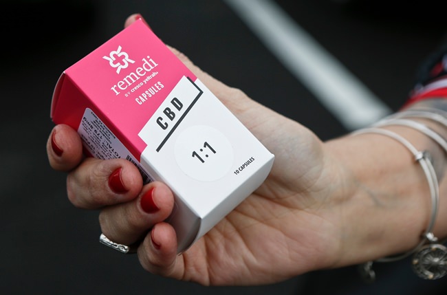 In this Thursday, Feb. 15, 2018 file photo, a woman holds the prescribed medical marijuana product used to treat her daughter’s epilepsy after making a purchase at a medical marijuana dispensary in Butler, Pa. Two new studies released on Monday, April 2, 2018 suggest that legalization of marijuana may reduce the prescribing of opioids. (AP Photo/Keith Srakocic)