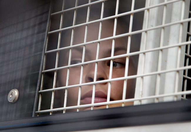 Anastasia Vashukevich sits inside a prison transport vehicle outside a courthouse in Pattaya, Tuesday, April 17. (AP Photo/Gemunu Amarasinghe)