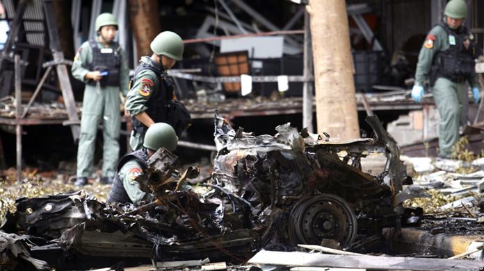 In this August 24, 2016 file photo, bomb squad officers examine the wreckage of a car after an explosion outside a hotel in Pattani province, southern Thailand. (AP Photo)
