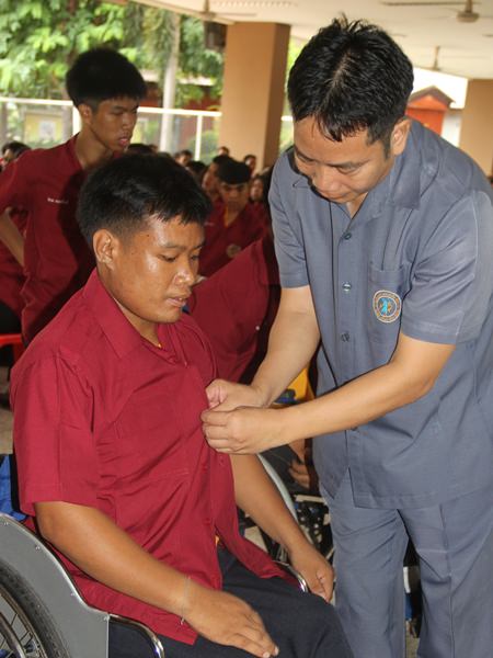 Teachers help the students into their new uniforms.