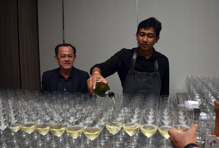 Teera Weerawan keeps watch as a waiter pours wine with poise and style. 