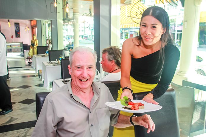 A charming waitress serves a Norwegian delicacy.