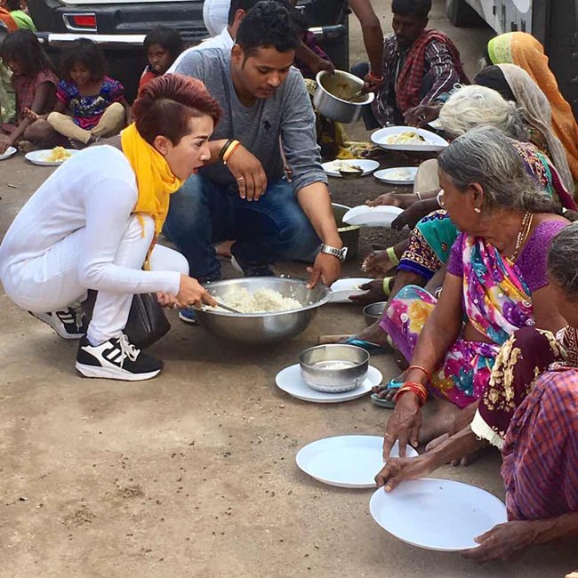 Maneeya and her friends serve rice and curries to the poor people in the village.