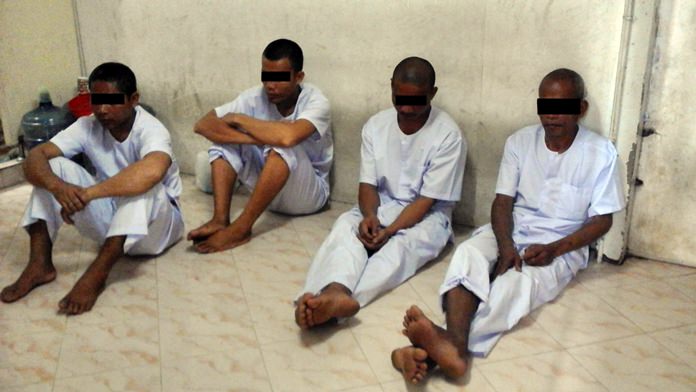 The disrobed Cambodians await their deportation.