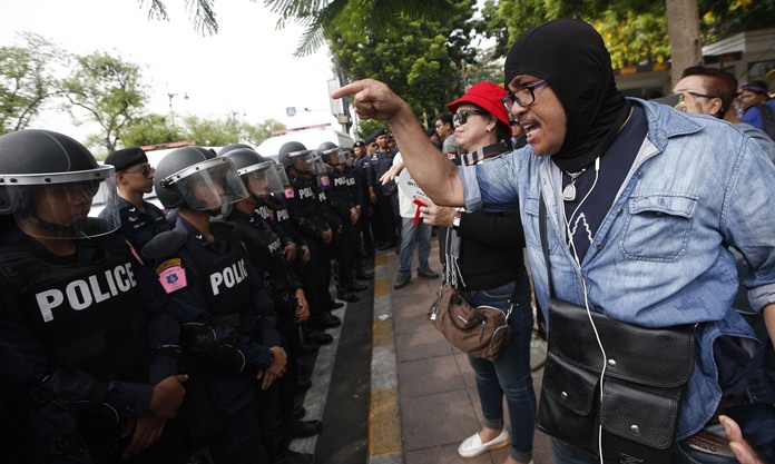 A pro-democracy protester shouts at police officers during a political gathering in Bangkok, Tuesday, May 22. (AP Photo/Sakchai Lalit)