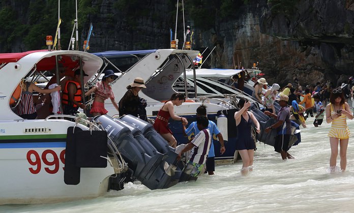 Droves of tourists arrive on powerboats.