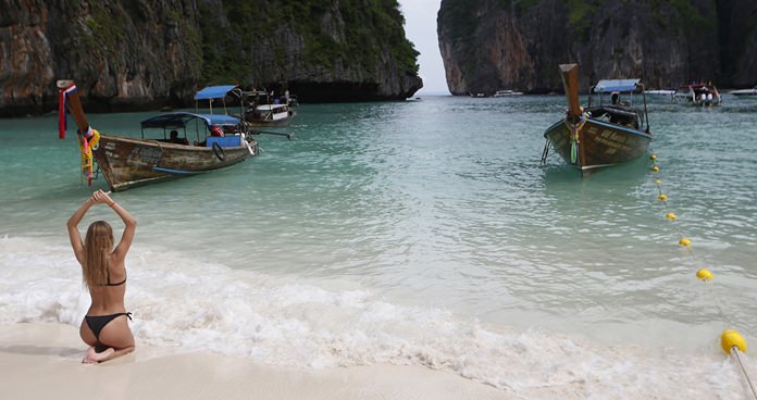 A tourist poses for a photo on Koh Phi Phi Leh.