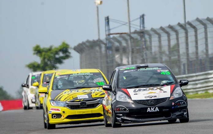 Victor Jensen steers his Honda Jazz (right) down the straight in the Super Production Class.