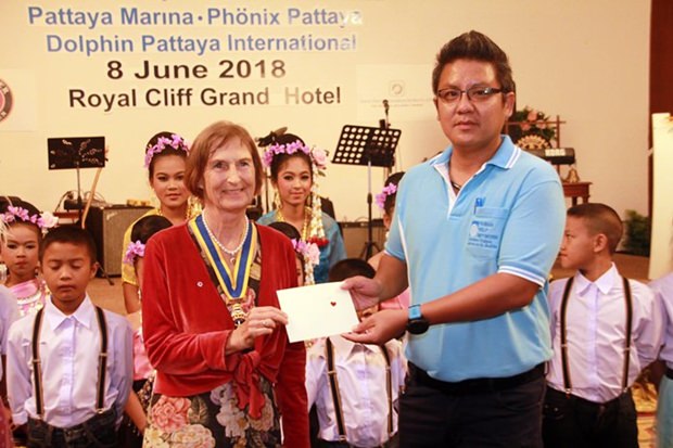 On behalf of the children from the CPDC, Siromes Akrapongpanich (right) receives a token of appreciation from President Margret Deter.