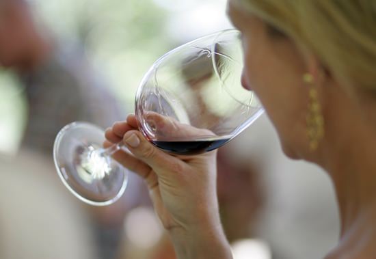 A woman evaluates the aroma of a wine in California. On Friday, June 15, 2018, National Institutes of Health Director Dr. Francis Collins announced the NIH is shutting down a study that was supposed to show if a single drink a day could prevent heart attacks, citing ethical problems that would undermine the credibility of its findings. (AP Photo/Eric Risberg, File)