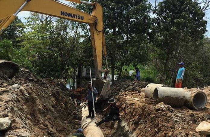 City workers install 60 centimeter tunnels to prevent floods near Pattaya Floating Market.