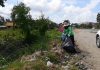 Nong Plalai public health workers clean up roadsides littered with trash following heavy rain.