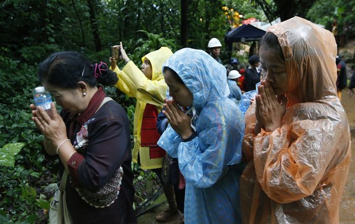 Relatives of 12 young soccer team members and their coach pray for their rescue, Wednesday, June 27, in Mae Sai, Chiang Rai province. (AP Photo/Sakchai Lalit)