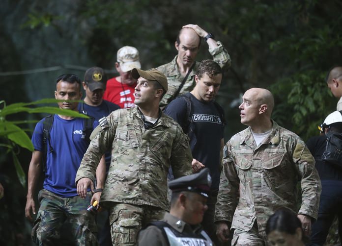 U.S. Special Operations Command Pacific Search and Rescue team personnel walk out of a cave where a young soccer team and their coach are believed to be missing, Thursday, June 28, 2018, in Mae Sai, Chiang Rai province, in northern Thailand. A U.S. military team and British cave experts joined the rescue effort for 12 boys and their soccer coach missing for five days inside the cave being flooded by near-constant rains. (AP Photo/Sakchai Lalit)