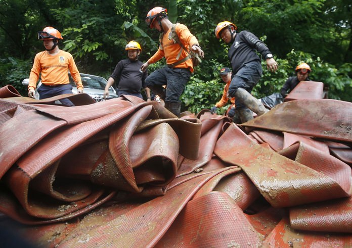 Rescue personnel arrange large hoses and additional water pumps to continue a search operation for a young soccer team and their coach in a large flooded cave, Thursday, June 28, 2018, in Mae Sai, Chiang Rai province, in northern Thailand. (AP Photo/Sakchai Lalit)