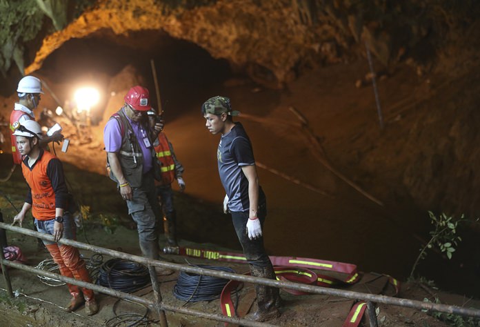 Rescue personnel walk out of the entrance to a cave complex where it's believed that 12 soccer team members and their coach went missing. (AP Photo/Sakchai Lalit)