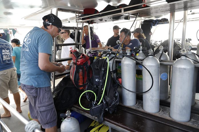 Divers check oxygen tanks on a boat at Chalong pier in Phuket as they prepare to recover bodies of passengers of a capsized tourist boat, Saturday, July 7. (AP Photo/Vincent Thian)