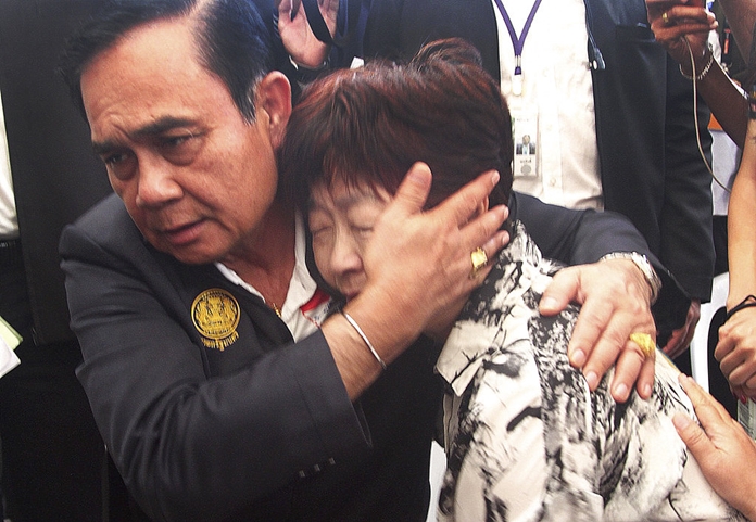 Thailand Prime Minister Prayuth Chan-ocha consoles a relative of a victim of last week's boat accident, Monday, July 9, on Phuket island. (AP Photo)